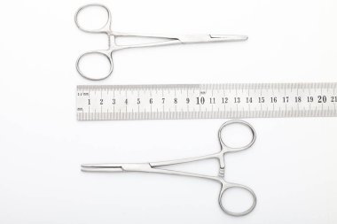 Çelik cerrahi aletler ve laboratuvar ekipmanları beyaz arka planda izole edilmiş. Profesyonel klinik aletleri. Tıbbi, cerrahi, ambulans ve veteriner konsepti. Yumuşak seçici odaklı yakın plan