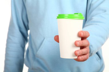 İnsan eli plastik kapaklı boş bir kahve fincanı tutar. Tek kullanımlık fincana çay ya da kahve konsepti. Metin veya logo için yeri ve yeri kopyala. Beyaz bir arkaplanda izole edilmiş