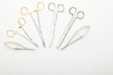 Çelik cerrahi aletler ve laboratuvar ekipmanları beyaz arka planda izole edilmiş. Profesyonel klinik aletleri. Tıbbi, cerrahi, ambulans ve veteriner konsepti. Yumuşak seçici odaklı yakın plan