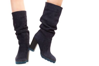 Bayan giysi ayakkabısı. Uzun ince dişinin bacakları yüksek topuklu uzun çizmeler giyer. Fotokopi alanı olan moda modeli. Klasik ve günlük kıyafet konsepti. Ayrıntılı yakın çekim stüdyo çekimi beyaz arkaplanda izole edildi