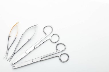 Çelik cerrahi aletler ve laboratuvar ekipmanları beyaz arka planda izole edilmiş. Profesyonel klinik aletleri. Tıbbi, cerrahi, ambulans ve veteriner konsepti. Yumuşak seçici odaklı yakın plan