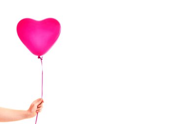 Kadın eli kırmızı kauçuk, şişme kalp şeklinde balon tutuyor. Aşk, ilişki, sevgililer günü ve doğum günü kutlaması konsepti. Stüdyo görüntüsü boş kopya alanı olan bulanık bir arkaplan üzerinde