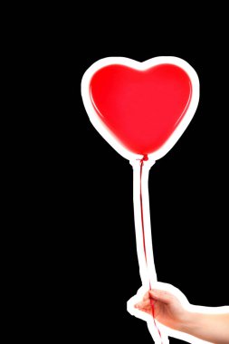 Kadın eli kırmızı kauçuk, şişme kalp şeklinde balon tutuyor. Aşk, ilişki, sevgililer günü ve doğum günü kutlaması konsepti. Boş kopya alanı olan dergi tarzı moda kolajı