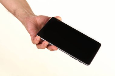 İnsan eli, avucunda boş bir krom ekran olan modern bir akıllı telefonu tutar. Teknoloji ve reklam kavramı. Ayrıntılı yakın çekim stüdyo çekimi soyut beyaz arka planda izole