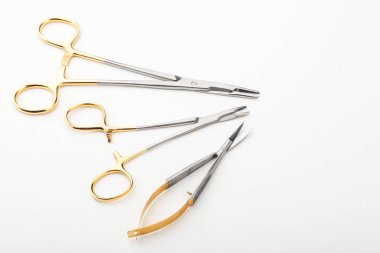 Çelik cerrahi aletler ve laboratuvar ekipmanları beyaz arka planda izole edilmiş. Profesyonel klinik aletleri. Tıbbi, cerrahi, ambulans ve veteriner konsepti. Yumuşak seçici odaklı yakın plan