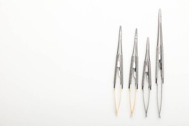 Çelik cerrahi aletler ve laboratuvar ekipmanları beyaz arka planda izole edilmiş. Profesyonel klinik aletleri. Tıbbi, cerrahi, ambulans ve veteriner konsepti. Yumuşak seçici odaklı yakın plan