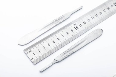 Çelik cerrahi aletler ve laboratuvar ekipmanları beyaz arka planda izole edilmiş. Profesyonel klinik aletleri. Tıbbi, cerrahi, ambulans ve veteriner konsepti. Yumuşak seçici odaklı yakın plan