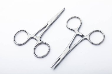 Çelik cerrahi aletler ve laboratuvar ekipmanları beyaz arka planda izole edilmiş. Profesyonel klinik aletleri. Tıbbi, cerrahi, ambulans ve veteriner konsepti. Yumuşak seçici odaklı yakın plan