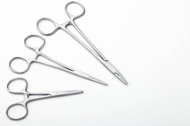 Çelik cerrahi aletler ve laboratuvar ekipmanları beyaz arka planda izole edilmiş. Profesyonel klinik aletleri. Tıbbi, cerrahi, ambulans ve veteriner konsepti. Yumuşak seçici odaklı yakın plan