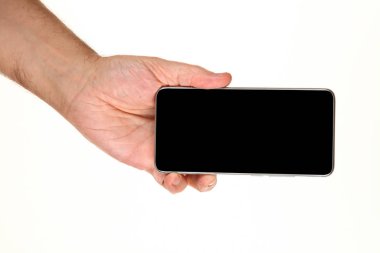İnsan eli, avucunda boş bir krom ekran olan modern bir akıllı telefonu tutar. Teknoloji ve reklam kavramı. Ayrıntılı yakın çekim stüdyo çekimi soyut beyaz arka planda izole
