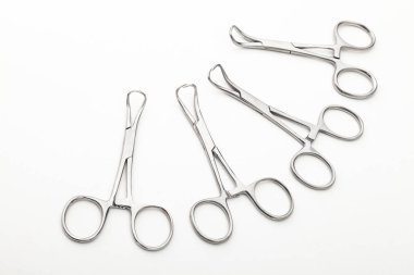 Çelik cerrahi aletler ve laboratuvar ekipmanları beyaz arka planda izole edilmiş. Profesyonel klinik aletleri. Tıbbi, cerrahi, ambulans ve veteriner konsepti. Yumuşak seçici odaklı yakın plan