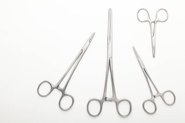 Çelik cerrahi aletler ve laboratuvar ekipmanları beyaz arka planda izole edilmiş. Profesyonel klinik aletleri. Tıbbi, cerrahi, ambulans ve veteriner konsepti. Yumuşak seçici odaklı yakın plan