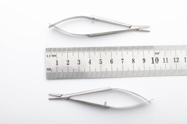 Çelik cerrahi aletler ve laboratuvar ekipmanları beyaz arka planda izole edilmiş. Profesyonel klinik aletleri. Tıbbi, cerrahi, ambulans ve veteriner konsepti. Yumuşak seçici odaklı yakın plan