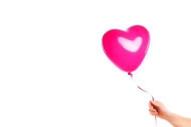 Kadın eli pembe kauçuk, şişme kalp şeklinde balon tutuyor. Aşk, ilişki, sevgililer günü ve doğum günü kutlaması konsepti. Stüdyo görüntüsü boş kopya alanı olan bulanık bir arkaplan üzerinde