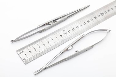 Çelik cerrahi aletler ve laboratuvar ekipmanları beyaz arka planda izole edilmiş. Profesyonel klinik aletleri. Tıbbi, cerrahi, ambulans ve veteriner konsepti. Yumuşak seçici odaklı yakın plan