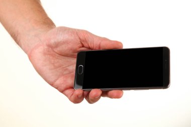 İnsan eli, avucunda boş bir krom ekran olan modern bir akıllı telefonu tutar. Teknoloji ve reklam kavramı. Ayrıntılı yakın çekim stüdyo çekimi soyut beyaz arka planda izole