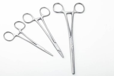 Çelik cerrahi aletler ve laboratuvar ekipmanları beyaz arka planda izole edilmiş. Profesyonel klinik aletleri. Tıbbi, cerrahi, ambulans ve veteriner konsepti. Yumuşak seçici odaklı yakın plan