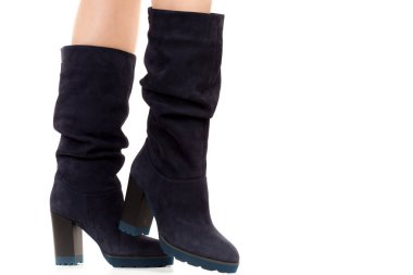 Bayan giysi ayakkabısı. Uzun ince dişinin bacakları yüksek topuklu uzun çizmeler giyer. Fotokopi alanı olan moda modeli. Klasik ve günlük kıyafet konsepti. Ayrıntılı yakın çekim stüdyo çekimi beyaz arkaplanda izole edildi