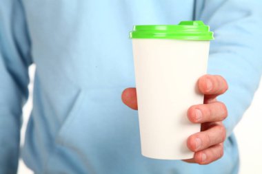 İnsan eli plastik kapaklı boş bir kahve fincanı tutar. Tek kullanımlık fincana çay ya da kahve konsepti. Metin veya logo için yeri ve yeri kopyala. Beyaz bir arkaplanda izole edilmiş