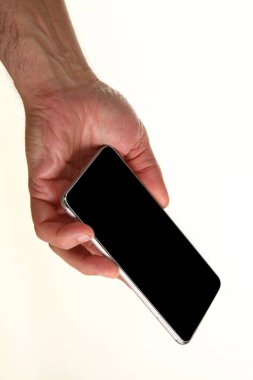 İnsan eli, avucunda boş bir krom ekran olan modern bir akıllı telefonu tutar. Teknoloji ve reklam kavramı. Ayrıntılı yakın çekim stüdyo çekimi soyut beyaz arka planda izole