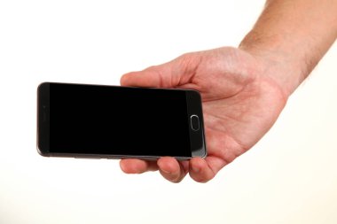 İnsan eli, avucunda boş bir krom ekran olan modern bir akıllı telefonu tutar. Teknoloji ve reklam kavramı. Ayrıntılı yakın çekim stüdyo çekimi soyut beyaz arka planda izole