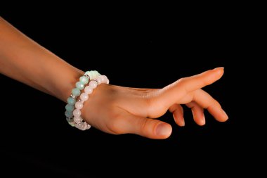 Güzel bir el yapımı mücevher bileziği. Renkli parlak boncuklar ve nötr manikürlü gevşek bir kadın bileği. Moda ve el işi aksesuarları. Yumuşak seçici odaklı yakın plan