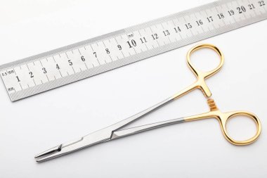 Çelik cerrahi aletler ve laboratuvar ekipmanları beyaz arka planda izole edilmiş. Profesyonel klinik aletleri. Tıbbi, cerrahi, ambulans ve veteriner konsepti. Yumuşak seçici odaklı yakın plan