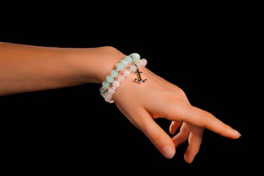 Güzel bir el yapımı mücevher bileziği. Renkli parlak boncuklar ve nötr manikürlü gevşek bir kadın bileği. Moda ve el işi aksesuarları. Yumuşak seçici odaklı yakın plan