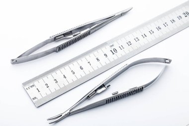 Çelik cerrahi aletler ve laboratuvar ekipmanları beyaz arka planda izole edilmiş. Profesyonel klinik aletleri. Tıbbi, cerrahi, ambulans ve veteriner konsepti. Yumuşak seçici odaklı yakın plan