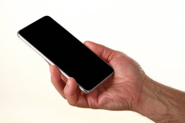 İnsan eli, avucunda boş bir krom ekran olan modern bir akıllı telefonu tutar. Teknoloji ve reklam kavramı. Ayrıntılı yakın çekim stüdyo çekimi soyut beyaz arka planda izole