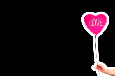 Kadın eli kırmızı kauçuk, şişme kalp şeklinde balon tutuyor. Aşk, ilişki, sevgililer günü ve doğum günü kutlaması konsepti. Boş kopya alanı olan dergi tarzı moda kolajı