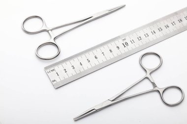 Çelik cerrahi aletler ve laboratuvar ekipmanları beyaz arka planda izole edilmiş. Profesyonel klinik aletleri. Tıbbi, cerrahi, ambulans ve veteriner konsepti. Yumuşak seçici odaklı yakın plan