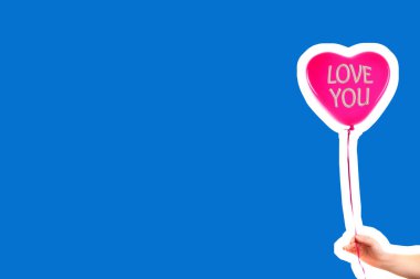 Kadın eli kırmızı kauçuk, şişme kalp şeklinde balon tutuyor. Aşk, ilişki, sevgililer günü ve doğum günü kutlaması konsepti. Boş kopya alanı olan dergi tarzı moda kolajı