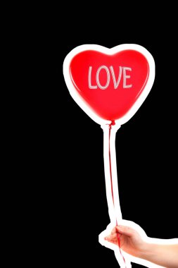 Kadın eli kırmızı kauçuk, şişme kalp şeklinde balon tutuyor. Aşk, ilişki, sevgililer günü ve doğum günü kutlaması konsepti. Boş kopya alanı olan dergi tarzı moda kolajı