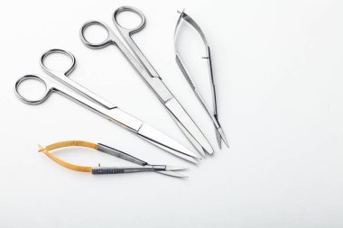 Çelik cerrahi aletler ve laboratuvar ekipmanları beyaz arka planda izole edilmiş. Profesyonel klinik aletleri. Tıbbi, cerrahi, ambulans ve veteriner konsepti. Yumuşak seçici odaklı yakın plan