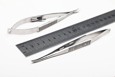 Çelik cerrahi aletler ve laboratuvar ekipmanları beyaz arka planda izole edilmiş. Profesyonel klinik aletleri. Tıbbi, cerrahi, ambulans ve veteriner konsepti. Yumuşak seçici odaklı yakın plan