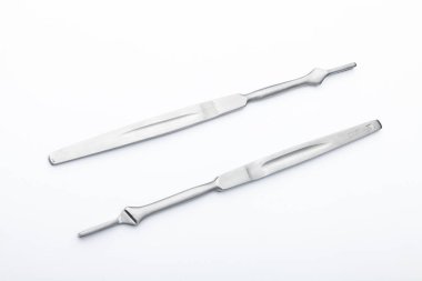 Çelik cerrahi aletler ve laboratuvar ekipmanları beyaz arka planda izole edilmiş. Profesyonel klinik aletleri. Tıbbi, cerrahi, ambulans ve veteriner konsepti. Yumuşak seçici odaklı yakın plan