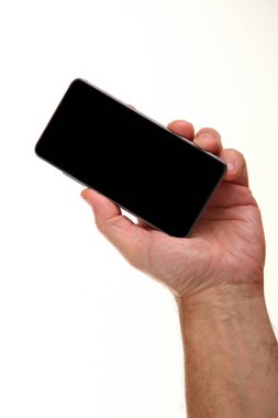 İnsan eli, avucunda boş bir krom ekran olan modern bir akıllı telefonu tutar. Teknoloji ve reklam kavramı. Ayrıntılı yakın çekim stüdyo çekimi soyut beyaz arka planda izole