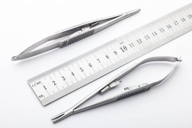 Çelik cerrahi aletler ve laboratuvar ekipmanları beyaz arka planda izole edilmiş. Profesyonel klinik aletleri. Tıbbi, cerrahi, ambulans ve veteriner konsepti. Yumuşak seçici odaklı yakın plan