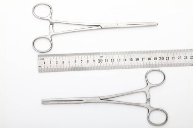 Çelik cerrahi aletler ve laboratuvar ekipmanları beyaz arka planda izole edilmiş. Profesyonel klinik aletleri. Tıbbi, cerrahi, ambulans ve veteriner konsepti. Yumuşak seçici odaklı yakın plan