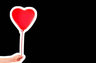 Kadın eli kırmızı kauçuk, şişme kalp şeklinde balon tutuyor. Aşk, ilişki, sevgililer günü ve doğum günü kutlaması konsepti. Boş kopya alanı olan dergi tarzı moda kolajı