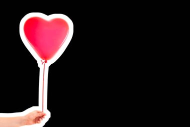 Kadın eli kırmızı kauçuk, şişme kalp şeklinde balon tutuyor. Aşk, ilişki, sevgililer günü ve doğum günü kutlaması konsepti. Boş kopya alanı olan dergi tarzı moda kolajı
