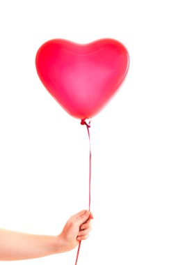 Kadın eli kırmızı kauçuk, şişme kalp şeklinde balon tutuyor. Aşk, ilişki, sevgililer günü ve doğum günü kutlaması konsepti. Stüdyo görüntüsü boş kopya alanı olan bulanık bir arkaplan üzerinde