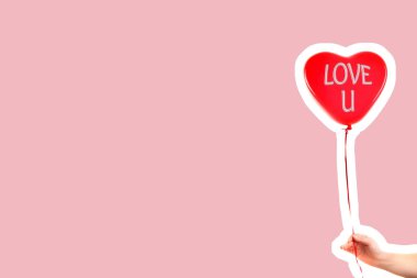 Kadın eli kırmızı kauçuk, şişme kalp şeklinde balon tutuyor. Aşk, ilişki, sevgililer günü ve doğum günü kutlaması konsepti. Boş kopya alanı olan dergi tarzı moda kolajı