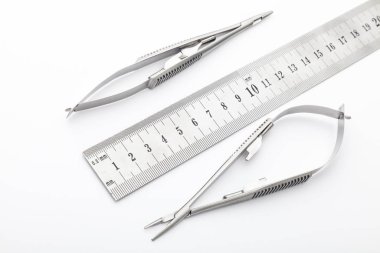 Çelik cerrahi aletler ve laboratuvar ekipmanları beyaz arka planda izole edilmiş. Profesyonel klinik aletleri. Tıbbi, cerrahi, ambulans ve veteriner konsepti. Yumuşak seçici odaklı yakın plan