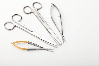 Çelik cerrahi aletler ve laboratuvar ekipmanları beyaz arka planda izole edilmiş. Profesyonel klinik aletleri. Tıbbi, cerrahi, ambulans ve veteriner konsepti. Yumuşak seçici odaklı yakın plan