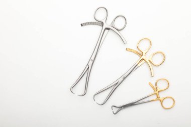 Çelik cerrahi aletler ve laboratuvar ekipmanları beyaz arka planda izole edilmiş. Profesyonel klinik aletleri. Tıbbi, cerrahi, ambulans ve veteriner konsepti. Yumuşak seçici odaklı yakın plan