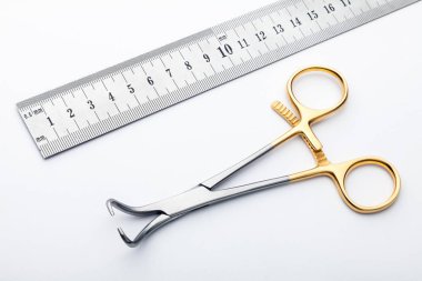 Çelik cerrahi aletler ve laboratuvar ekipmanları beyaz arka planda izole edilmiş. Profesyonel klinik aletleri. Tıbbi, cerrahi, ambulans ve veteriner konsepti. Yumuşak seçici odaklı yakın plan