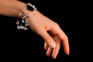 Güzel bir el yapımı mücevher bileziği. Renkli parlak boncuklar ve nötr manikürlü gevşek bir kadın bileği. Moda ve el işi aksesuarları. Yumuşak seçici odaklı yakın plan