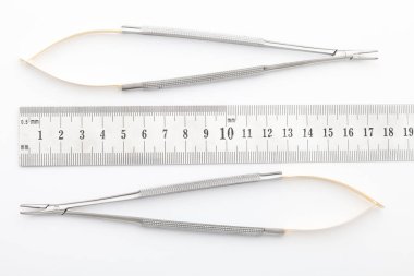 Çelik cerrahi aletler ve laboratuvar ekipmanları beyaz arka planda izole edilmiş. Profesyonel klinik aletleri. Tıbbi, cerrahi, ambulans ve veteriner konsepti. Yumuşak seçici odaklı yakın plan